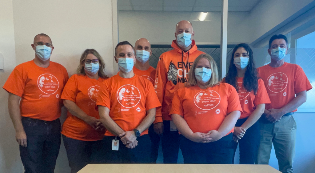cpc staff wearing orange truth and reconciliation day t-shirts and posing for a photo.